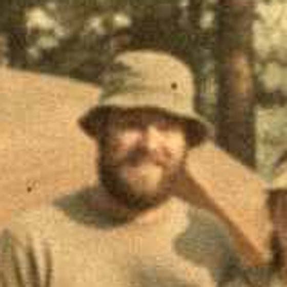 A father's face in a faded, scratched 1994 camping photo, only a few millimetres wide in the print