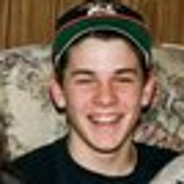 The small original: a grinning teenage boy in a cap
